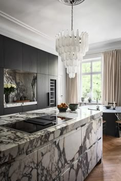 a kitchen with marble counter tops and an island in front of a large glass window