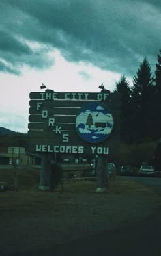 there is a sign that says the city of forks welcomes you on it in front of some trees