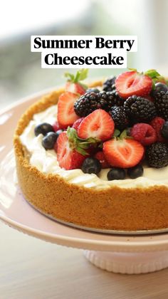 there is a cheesecake with berries on top and blueberries in the middle, sitting on a pink plate