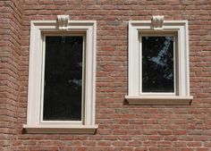 two windows on the side of a brick building