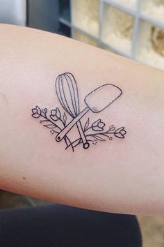 a woman's arm with a tattoo on it that has a kitchen utensil and flowers