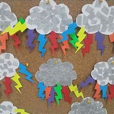 paper mache clouds and lightnings are displayed on a bulletin board