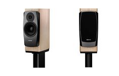 two speakers are shown side by side, one is black and the other is wood