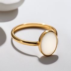 a close up of a gold ring on a white surface with shadows coming from it