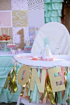 a table topped with cake and cupcakes next to a chair covered in tassels