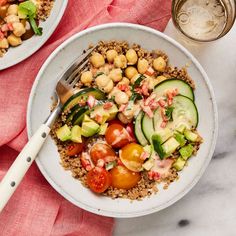 two white plates filled with food on top of a marble table next to silverware