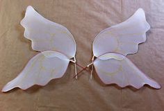 two white paper butterflies on a brown sheet