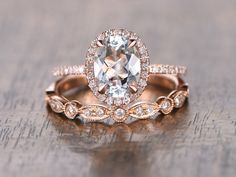 two wedding rings with an oval cut diamond in the center