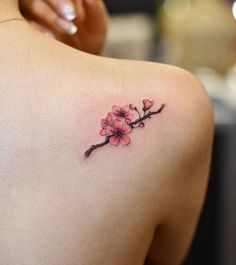 the back of a woman's shoulder with pink flowers on it