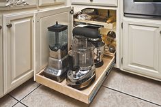 an open drawer in the middle of a kitchen with coffee maker and blender on it