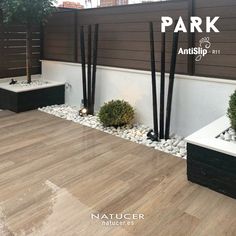 an outdoor area with plants and rocks on the ground next to a wooden fence that says park