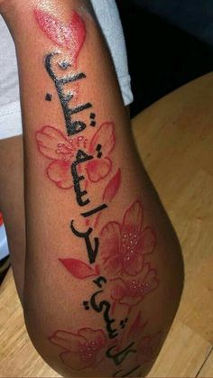 a woman's arm with flowers and the word love written on it in black ink