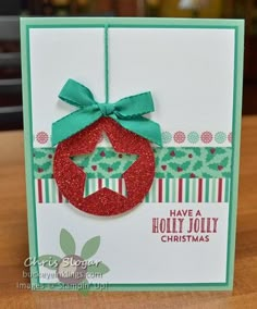 a christmas card with a red ornament on it