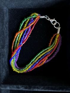 This 6 strand seed bead bracelet is the perfect way to adorn your wrist with a little extra Pride. Each strand holds one color of the rainbow-- red, orange, yellow, green, blue and violet. Bracelet is finished off with metal accent gather and lobster clasp for closure. Listed length is aproximate as all items are handmade.  25% of the proceeds from this item will benefit the 2025 AIDS LifeCycle. *send a message if an extra-long bracelet length is needed, I'm happy to customize!* Rainbow Beaded Bracelet Jewelry, Rainbow Faceted Round Beads Bracelets, Rainbow Multi-strand Jewelry For Gifts, Rainbow Beaded Bracelets With Faceted Beads For Gift, Rainbow Faceted Beads Bracelet As Gift, Rainbow Faceted Beads Bracelet For Jewelry Making, Multi-strand Bracelets With Colorful Beads For Jewelry Making, Handmade Multicolor Multi-strand Friendship Bracelets, Multicolor Beaded Multi-strand Bracelets