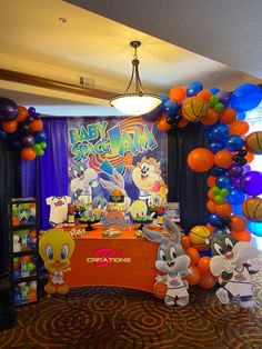 an indoor basketball themed birthday party with balloons and streamers on the ceiling, along with decorations