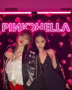 two young women standing next to each other in front of a neon sign that says pinkchella