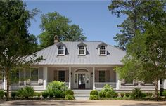 a white house surrounded by trees and bushes