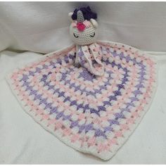 a crocheted blanket with a stuffed unicorn on it