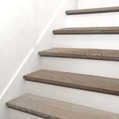 some wooden stairs with white walls and wood flooring