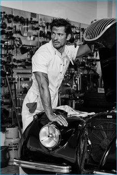 a man working on an old car in a garage