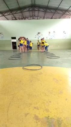 a group of young people standing on top of a yellow floor next to each other