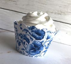 a cupcake with white frosting and blue flowers