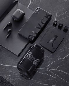 an assortment of electronics and gadgets laid out on a marble counter top with the words coca cola printed on it