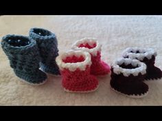 four crocheted baby booties sitting on top of a bed