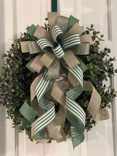 a green and white wreath hanging on the front door