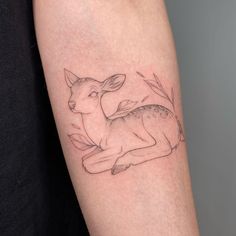 a small deer tattoo on the arm