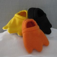 three pairs of slippers sitting on top of a white bed next to each other