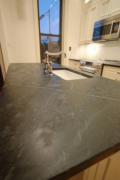 a kitchen counter with a sink and oven in it