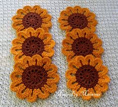 two crocheted sunflowers are sitting on the floor next to each other