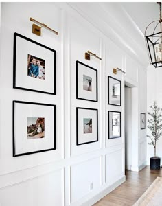 a hallway with white walls and pictures on the wall