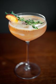 an apple cider cocktail garnished with fresh herbs