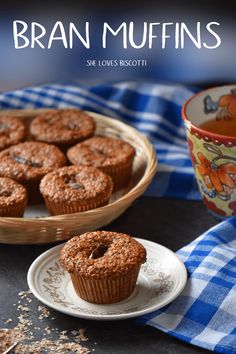 some muffins are sitting on a plate next to a cup of tea and a blue checkered towel