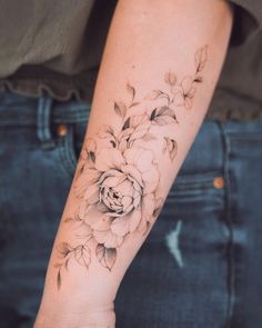 a woman's arm with a flower tattoo on the left side of her arm