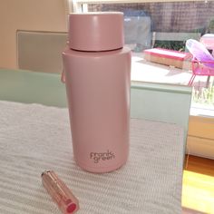 a pink insulated water bottle sitting on top of a table