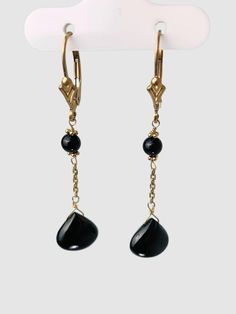 Onyx 2 station drop earrings. Earrings contain a pair of 9.8mm wide smooth onyx drops hang from yellow gold chain with a pair of 4.1mm round beads on 14k yellow gold lever backs. Earrings are 1.8" long. Metal - 14k Yellow Gold Gemstones - Onyx Length - 1.8" Elegant Onyx Jewelry For Evening, Luxury Black Drop Jewelry, 14k Gold Dangle Earrings For Evening, 14k Gold Drop Jewelry For Evening, Luxury Yellow Gold Onyx Earrings, Elegant Onyx Drop Jewelry, Classic 14k Gold Briolette Earrings, Elegant Onyx Dangle Jewelry, Yellow Gold Drop Jewelry For Evening