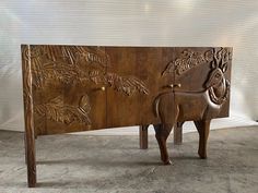 a carved wooden cabinet with an animal on it's front and side panels in the back