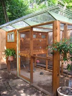 a small chicken coop in the middle of a yard with trees and bushes around it