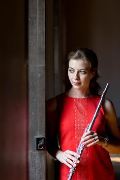 a woman in a red dress holding a flute