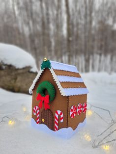 a gingerbread house with candy canes and wreath on the roof in the snow