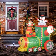 an inflatable christmas train with snowmen and santa clause on it's side