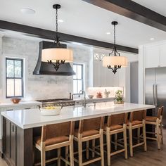 a large kitchen with an island and chairs