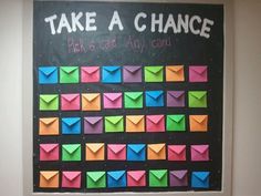 a bulletin board with colorful envelopes on it that says, take a chance pick a card any card