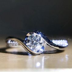 a diamond ring sitting on top of a wooden table