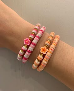 three bracelets with flowers on them sitting on a person's arm