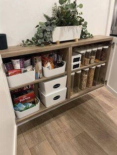 a shelf filled with lots of food and some white containers on top of it next to a door