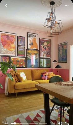 a living room filled with furniture and pictures on the wall next to a wooden table